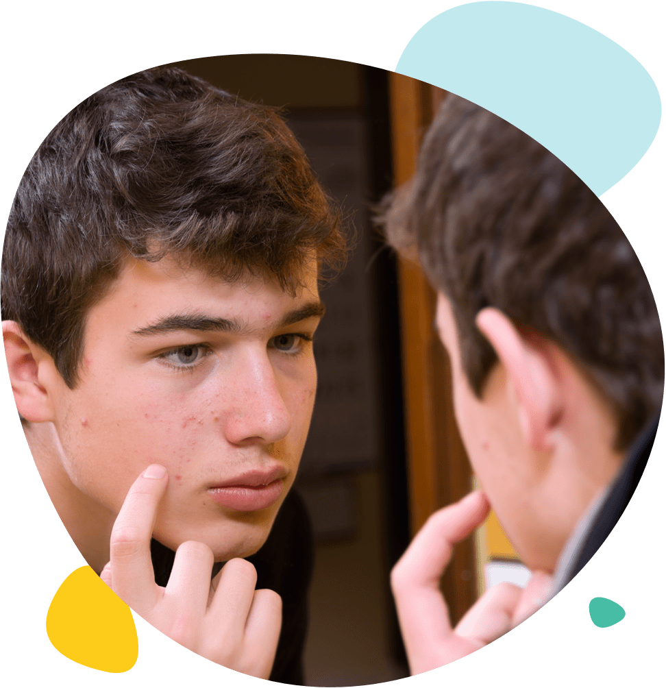 Un jeune homme regarde ses boutons dans le miroir