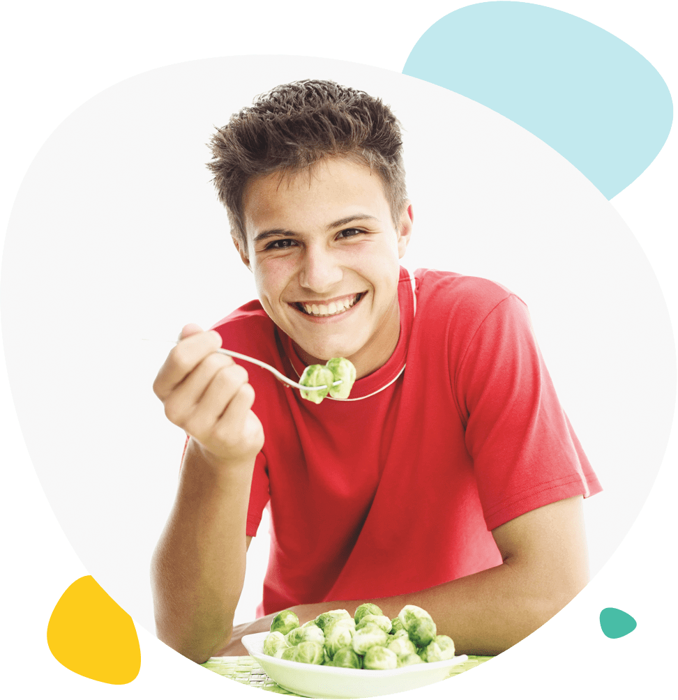 Un adolescent mange des choux de Bruxelles Un adolescent mange des choux de Bruxelles