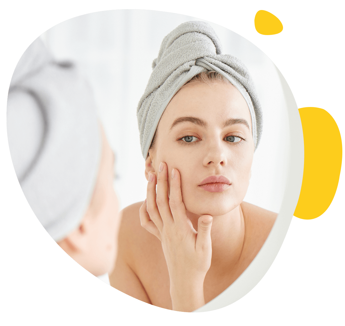 Une jeune fille se regarde dans un miroir de la salle de bain